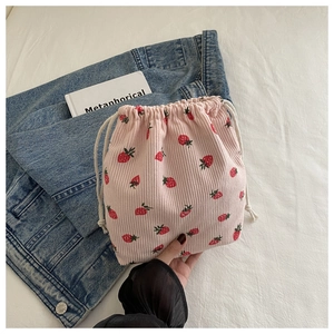 Gros plan détaillé du sac à cordon en velours côtelé rose avec motif fraises