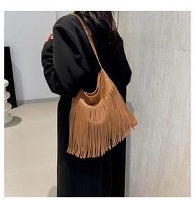 Detail of brown boho hobo bag featuring flowing tassels and adjustable leather strap