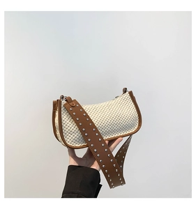Detail of the woven straw material and brown leather strap with silver metal studs