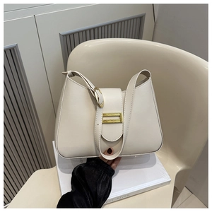 Detailed view of cream leather underarm bag with gold hardware and adjustable strap