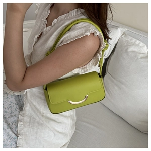 Détail du sac baguette vert avocat avec boucle en métal et bandoulière nouée