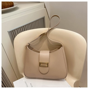 Detailed view of beige faux leather shoulder bag featuring a sleek gold geometric buckle