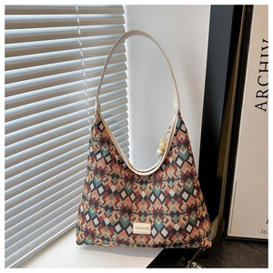 Detail of hobo bag with contrast diamond texture, fashion label and white leather strap