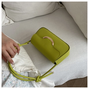 Détail du petit sac bandoulière vert avocat avec boucle dorée et bandoulière nouée