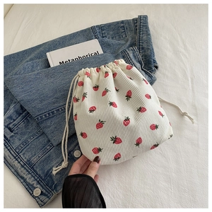 Gros plan d'un sac à cordon en velours côtelé blanc avec motif fraise rouge