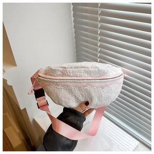 Dettaglio del tessuto rosa e bianco a bolle su una borsa a tracolla alla moda con cerniera