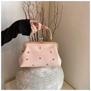 Pochette rosa con borchie a cuore dorate e dettagli del manico in metallo inciso