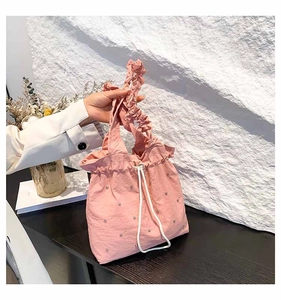 Detail of pink drawstring bucket bag with sparkling rhinestones and ruffled handle