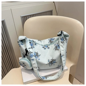Détail du sac à bandoulière en velours côtelé bleu clair avec imprimé fleuri et petit porte-monnaie