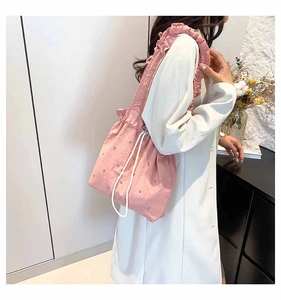 Detail of pink rhinestone tote with drawstring closure and ruffled shoulder strap