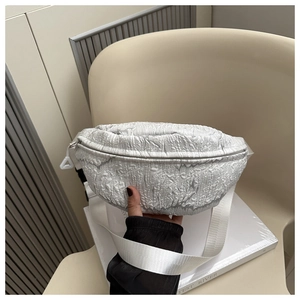 Detail shot of the white bubble textured fabric and wide strap on the casual chest bag