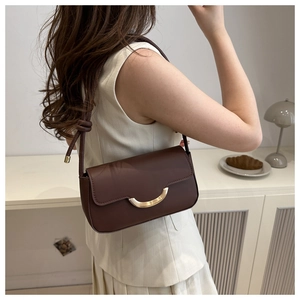 Détail du sac à bandoulière marron vintage avec cuir mat et boucle dorée en croissant