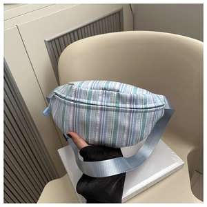 Détail d'un sac de poitrine à rayures avec sangle en nylon bleu et fermeture éclair