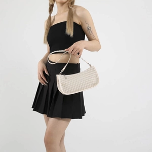 Minimalist cream woven shoulder bag with checkered texture worn by a model
