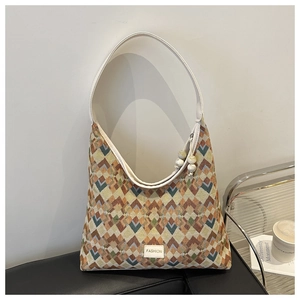 Detail of colorful zigzag woven tote bag with FASHION label and white shoulder strap