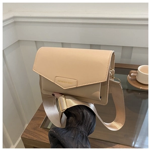 Close-up of beige leather crossbody bag with wide fabric strap and embossed logo