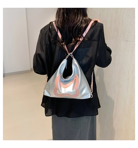 Rückansicht eines Models mit einer glänzenden silber-rosa Tragetasche als Rucksack