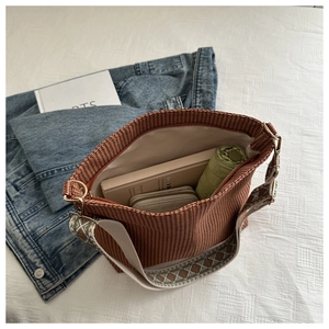 Detail of the brown woven tote bag interior showing large capacity and embroidered strap