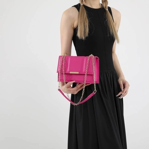 Rose pink quilted chain crossbody bag for women styled with a black dress in studio