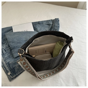 Open view of black woven tote bag showing large capacity with ethnic embroidered strap