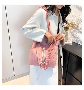 Detailed shot of pink pleated tote bag with ruffles and adjustable white drawstring cord