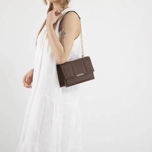 Minimalist brown square crossbody bag with quilted vertical lines and gold chain strap