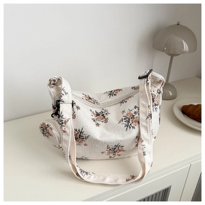 Détail du sac hobo en velours côtelé fleuri avec petit porte-monnaie et large bandoulière
