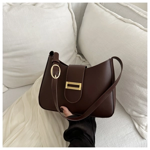Detail of vintage brown shoulder bag showing golden clasp and smooth leather texture