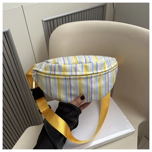 Gros plan détaillé du sac de poitrine en toile rayée avec sangle jaune et boucle