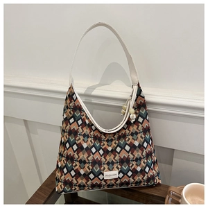 Detail of colorful geometric diamond pattern shoulder bag with a beaded charm