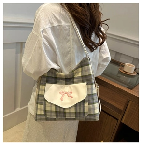 Detail of checkered canvas tote bag with pink bow embroidery on white pocket flap