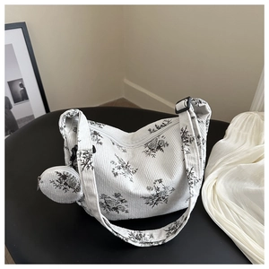 Détail du sac hobo en velours blanc avec imprimé floral vintage et mini porte-monnaie rond
