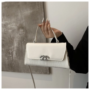 Detailed close-up of white crossbody bag featuring premium crocodile pattern and silver hardware