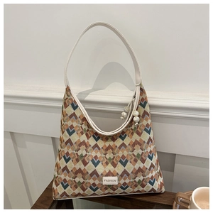 Detail of woven tote bag featuring colorful geometric patterns and white fashion label