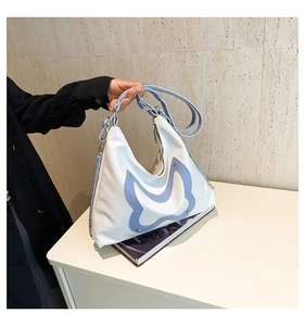 Nahaufnahme der weißen Hobo-Tasche mit blauem Schmetterling und silberner Metallkette