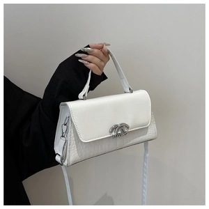Detail of white leather handbag with faux crocodile texture and silver metal clasp