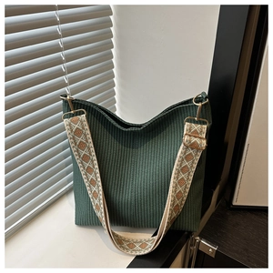 Détail du sac hobo tissé vert foncé avec une large bandoulière jacquard géométrique