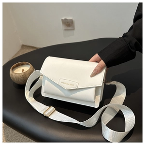 Close-up of white crossbody bag with envelope flap and adjustable wide nylon shoulder strap