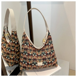 Detail of colorful geometric pattern tote bag with leather strap and fringe bead charm