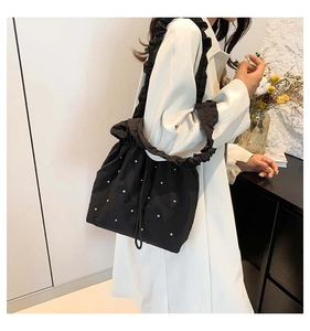 Detail of black drawstring bucket bag with silver rhinestones and scrunchie strap design