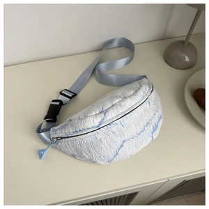 Close-up of light blue bubble textured waist bag with a nylon strap and triangle charm