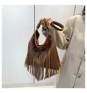 Detail of vintage brown pebble leather tote bag with long fringe tassels and wide strap