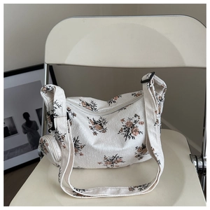 Détail d'un sac d'épaule en velours côtelé fleuri avec petit porte-monnaie rond