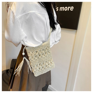 Detail of bohemian crochet crossbody bag with long tassels and wooden bead accents