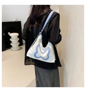Detailansicht einer weißen Schultertasche mit hellblauem Schmetterling und Kettenriemen