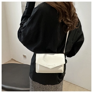 White leather envelope bag with FASHION & BAGS text shown cross-body on a model