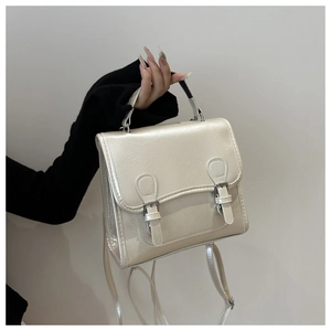 Detail of pearlescent white leather bag with silver metal buckles and top handle
