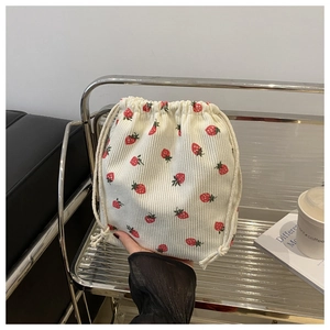 Détail du pochon imprimé fraises en velours côtelé avec cordon de serrage blanc
