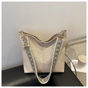 Detail of hobo bucket bag in beige woven fabric with bohemian jacquard shoulder strap