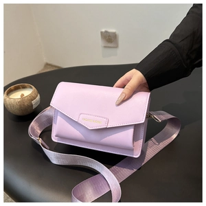 Detail of lavender crossbody bag with wide strap and embossed fashion lettering